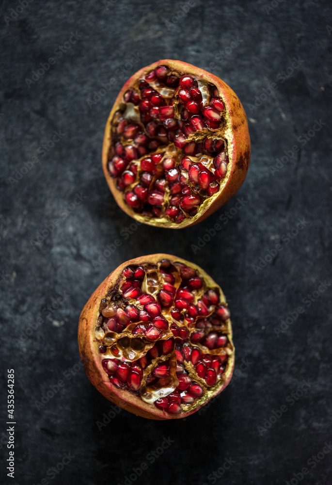 Closeup of half fresh pomegranate on black background