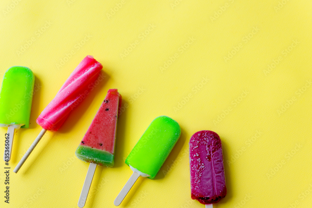 Closeup aerial view of colorful ice cream on yellow background