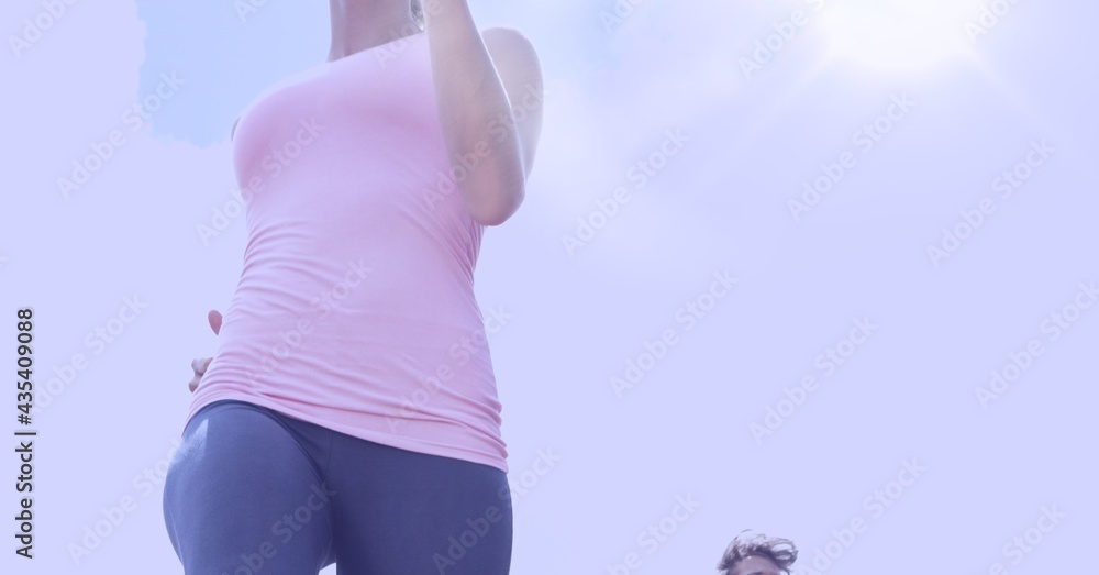 Composition of midsection of fit woman running in countryside with copy space and sun shining