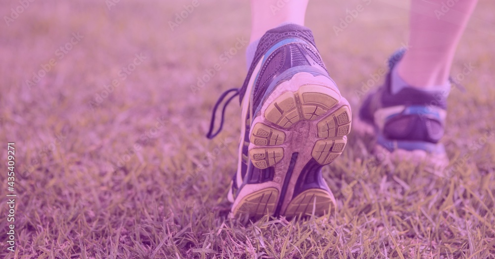 Composition of womans legs in running shoes and pink tint