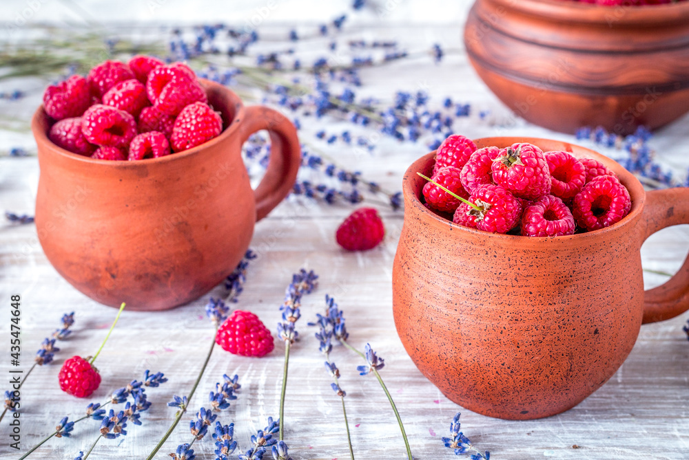 raspberry in pottery cup with lavander on wooden background