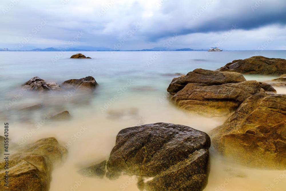 海滩、大海和美丽的云朵的景观。海滩上的岩石。