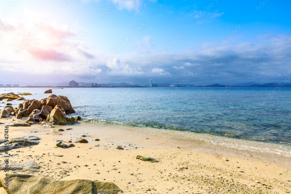 海滩、大海和蓝天上美丽的云朵的景观。海滩上的岩石。