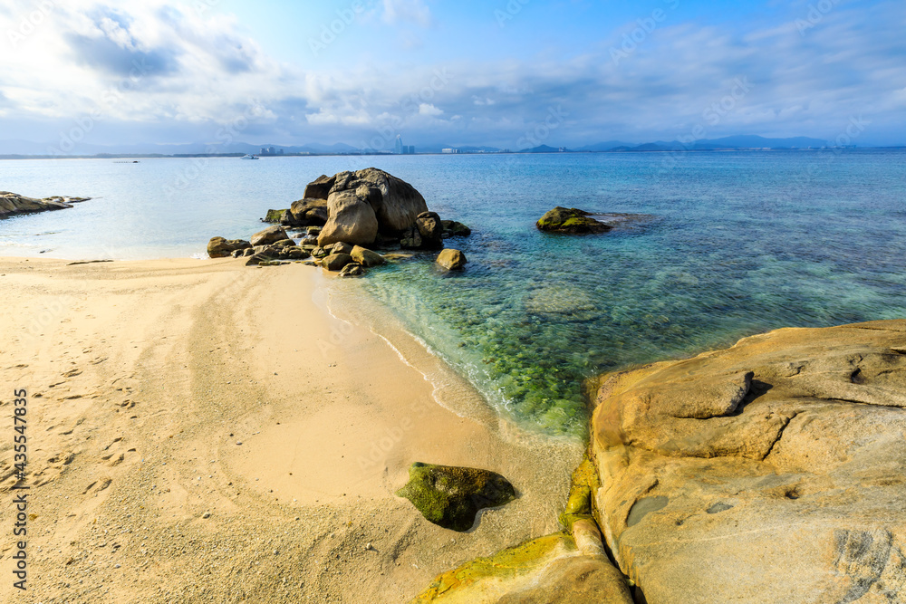 海滩、大海和蓝天上美丽的云朵的景观。海滩上的岩石。