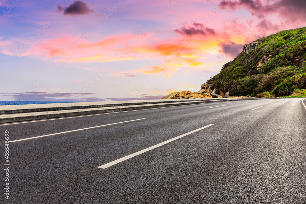 Asphalt road and beautiful seaside scenery at sunset.