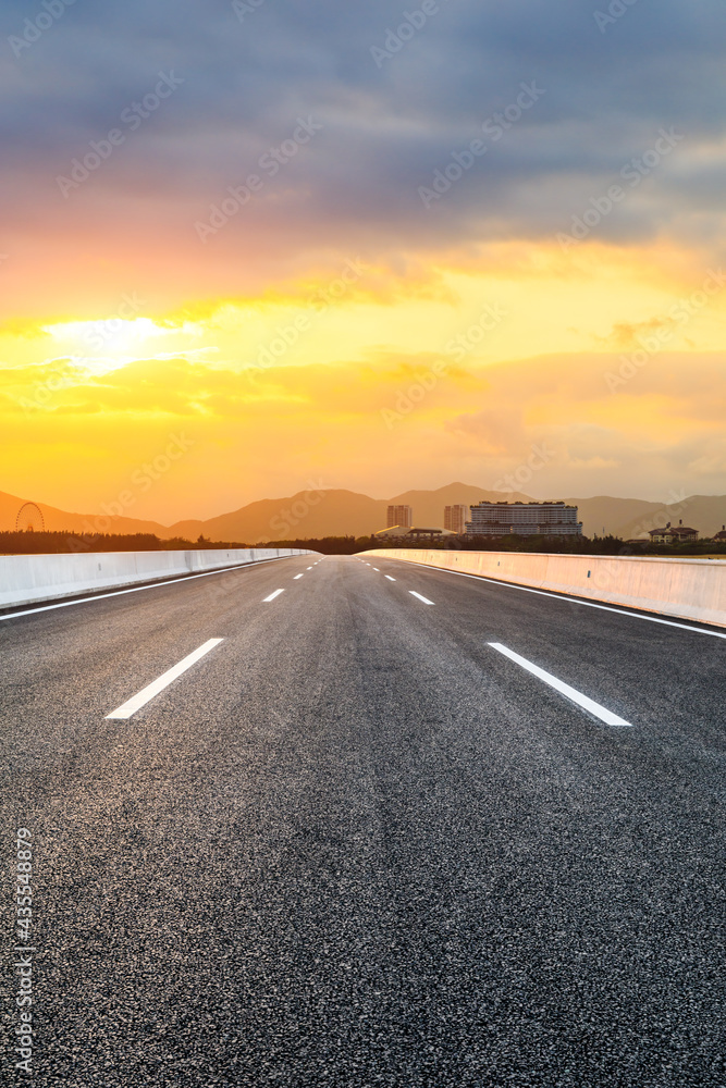 Asphalt road and beautiful seaside scenery at sunset.