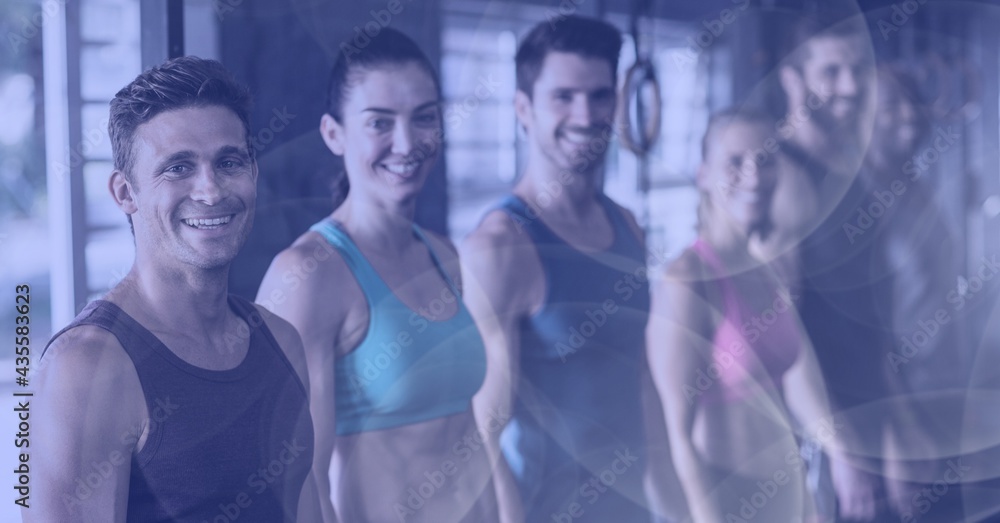 Composition of smiling men and women in fitness class with spot lights