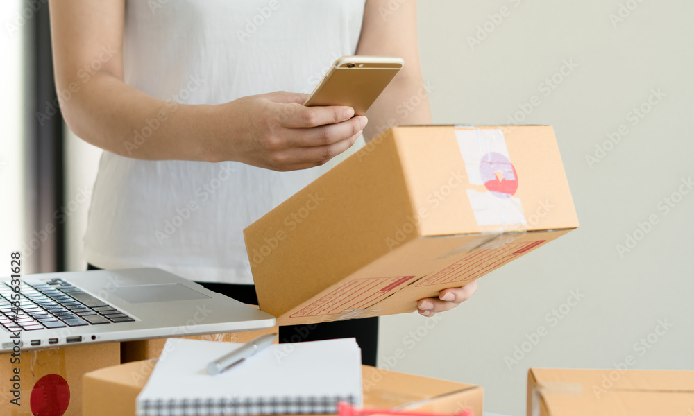 Asian business owner working at home with packing box of her online store prepare to deliver product