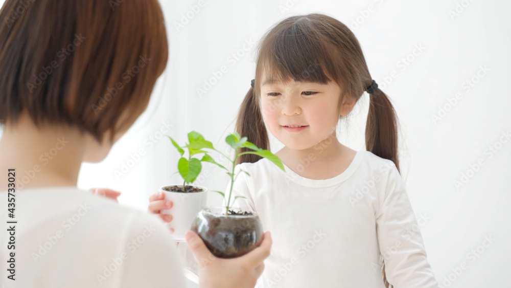 観葉植物を持つ娘と母