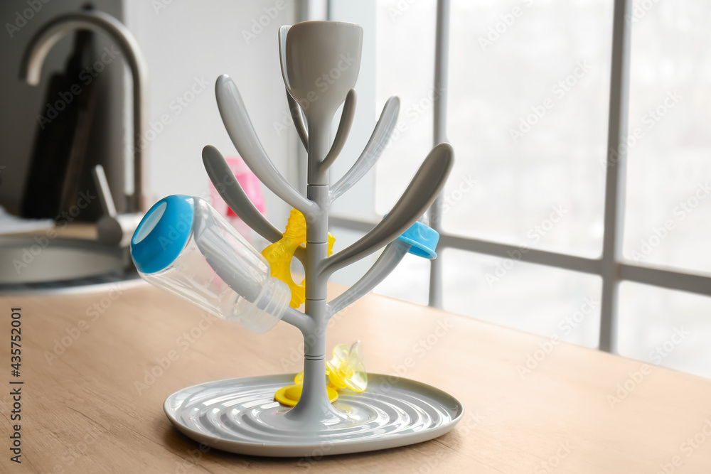 Drying rack for baby bottles on table in kitchen