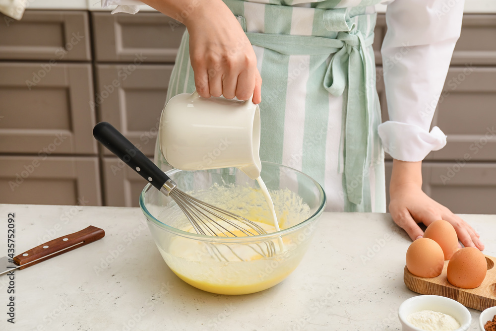 Woman preparing pastry in kitchen