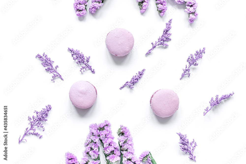 macaroons and flowers for light breakfast on white desk background top view