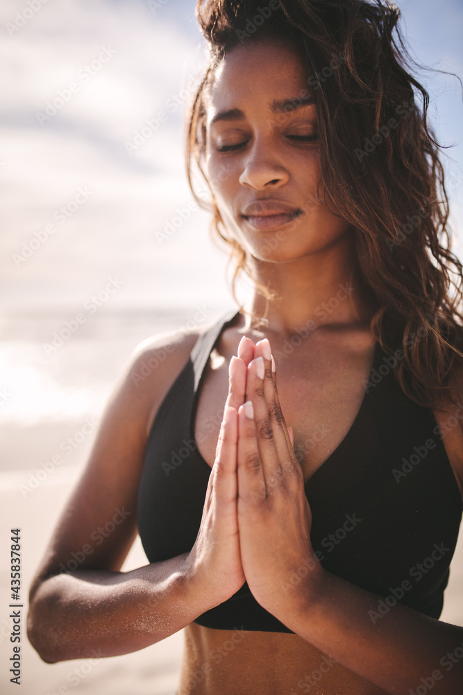 Woman meditating with hands joined and eyes closed