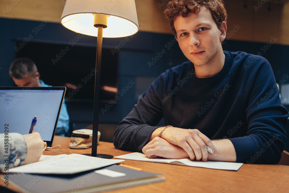 Male student sitting at library