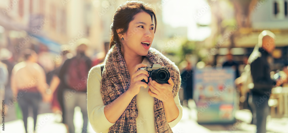 亚洲女性旅行者手持相机徒步旅行，拍摄生活方式的人城市人