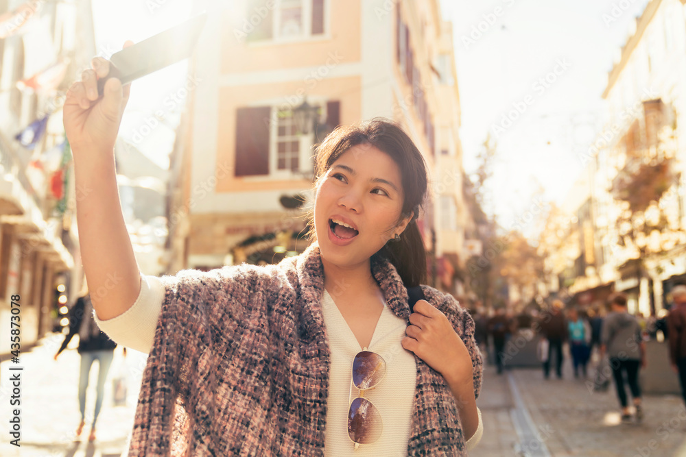 亚洲女性旅行者手持相机徒步旅行，拍摄生活方式的人城市人