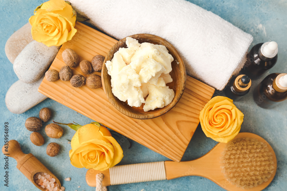 Composition with shea butter, bath supplies and flowers on color background