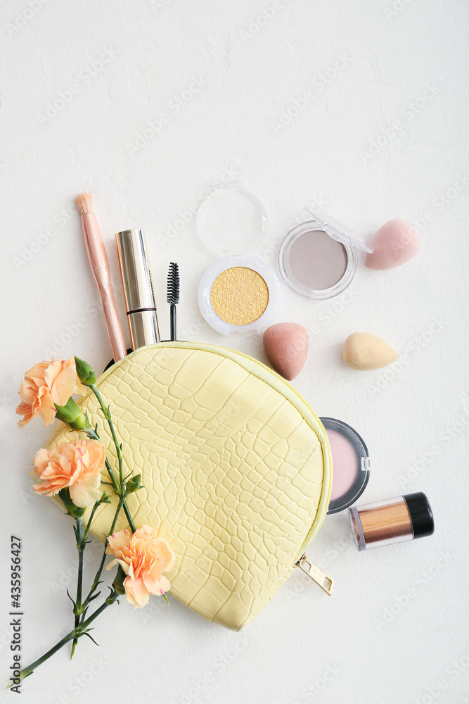 Stylish bag with decorative cosmetics on light background