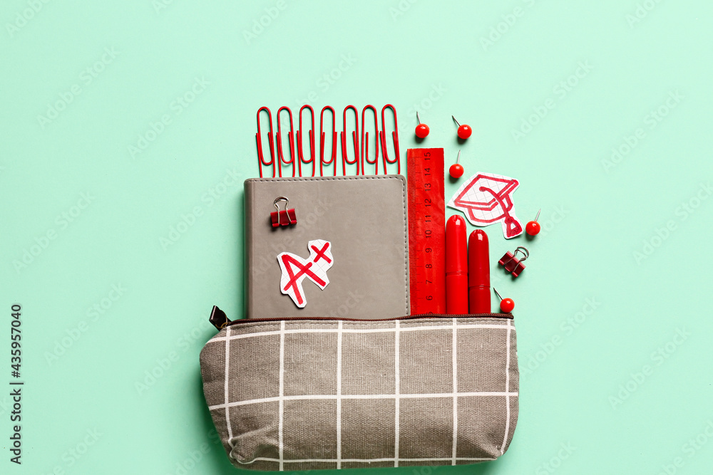 Pencil case and stationery on color background