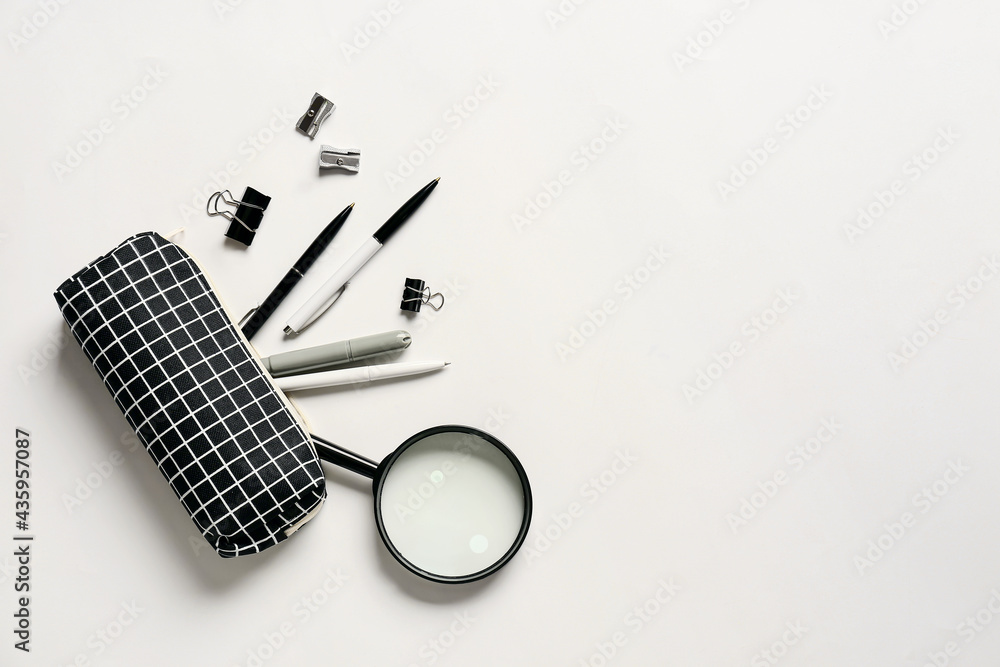 Pencil case and stationery on white background