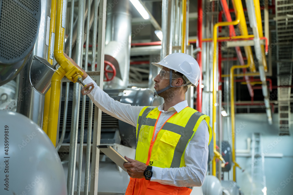 Engineer checking and maintenance technical data of system equipment condenser Water pump and piping