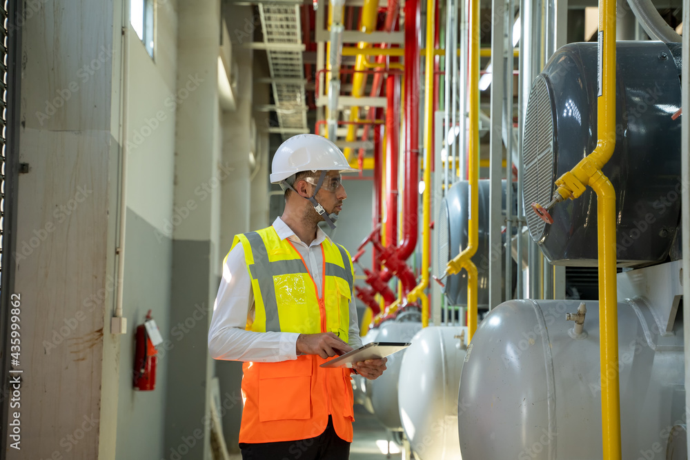 Engineer checking the valve equipment in a boiler at control room of a modern thermal power plant at