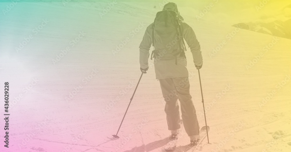 Composition of skier skiing down in mountains with green to yellow tint