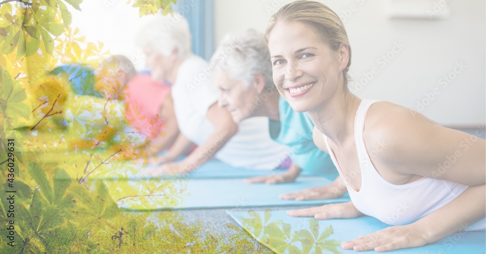 Composition of female instructor senior man and women exercising in fitness class with tree overlay