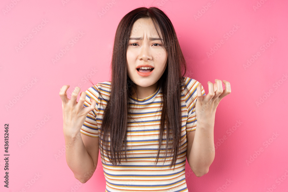 Young Asian woman posing on pink background