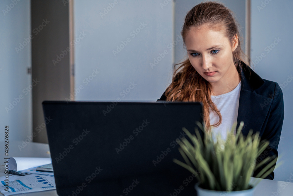 Young businesswoman work using laptop computer at the office desk. Business internet concept.