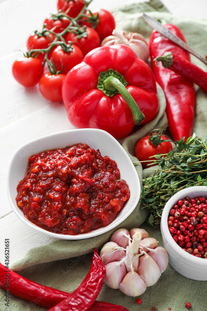 Composition with tasty chili sauce and ingredients on light wooden background, closeup