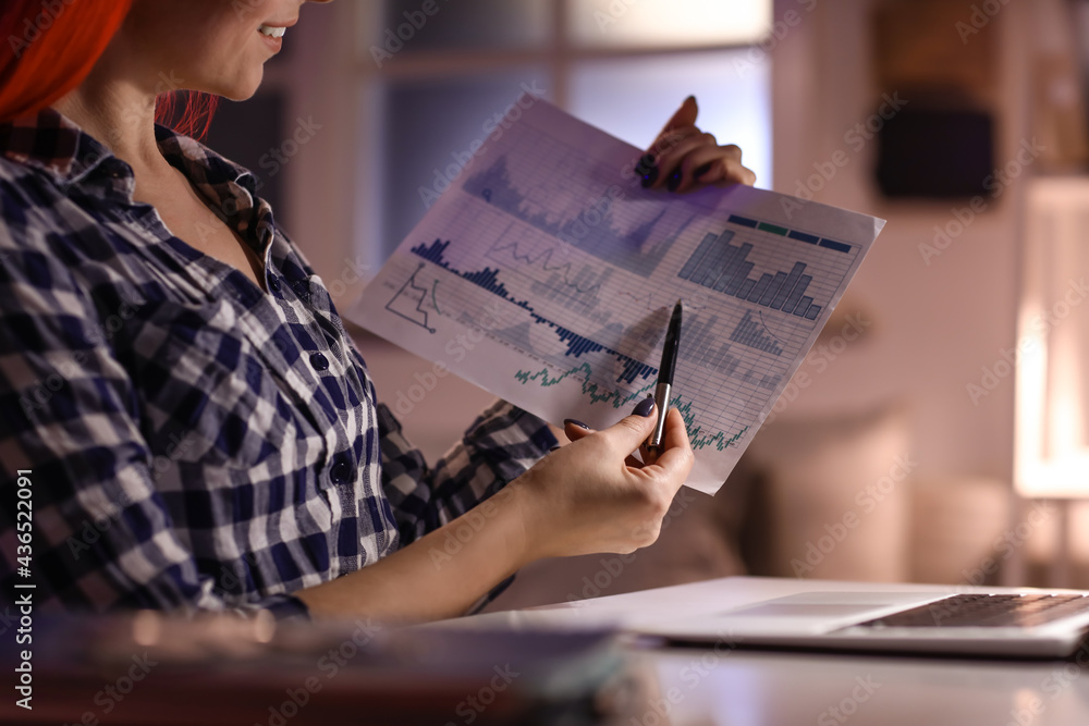 Beautiful woman with chart in office at night