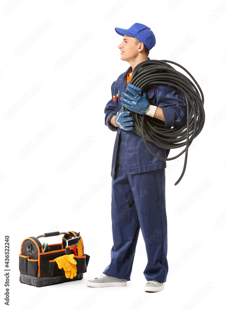 Young electrician with cables on white background