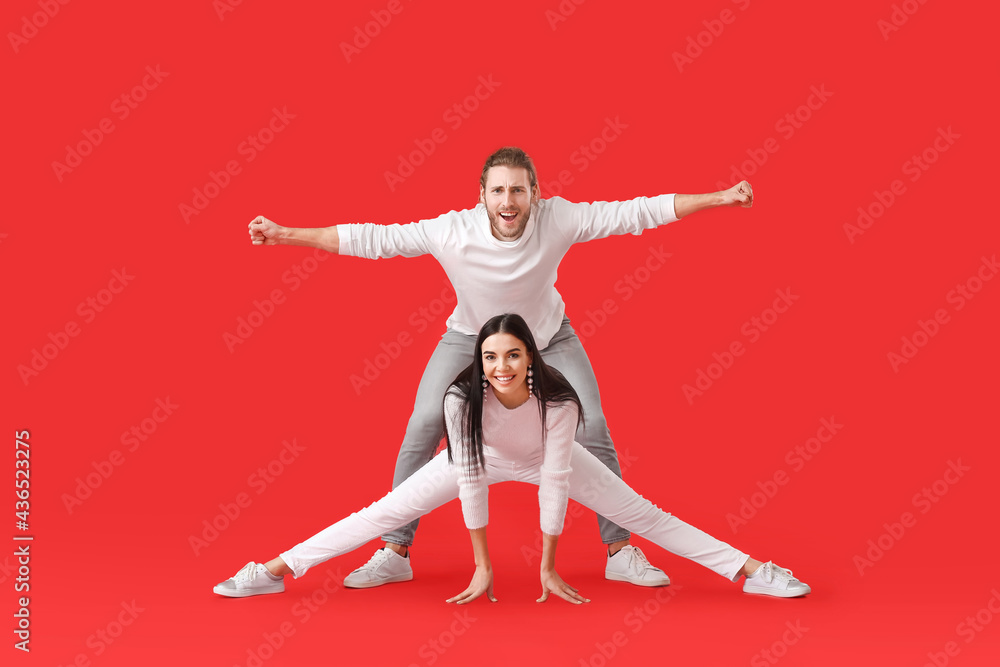 Happy young couple dancing on color background