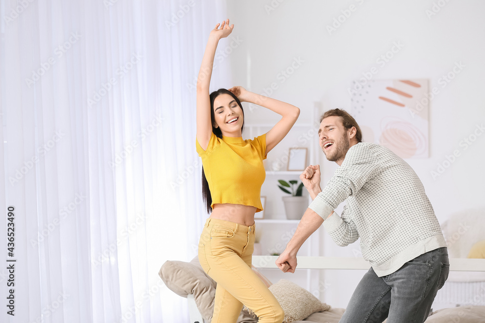 Happy young couple dancing at home