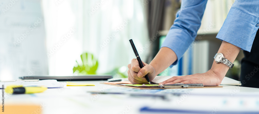 Hand of Businesswoman work in office write paperwork on table with pen