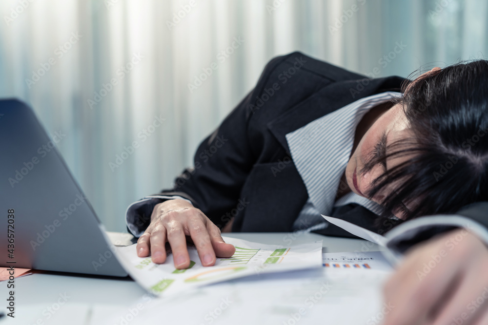 Businesswoman sleep on computer table feel tired from work in office.