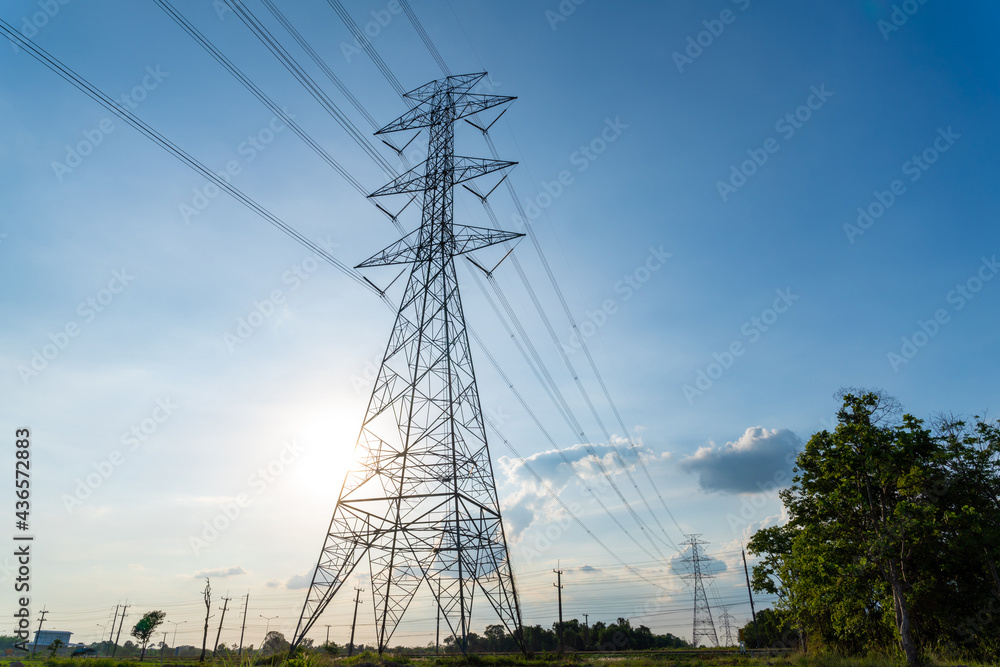 High voltage electric transmission tower, high voltage post, High voltage tower near sunset blue sky