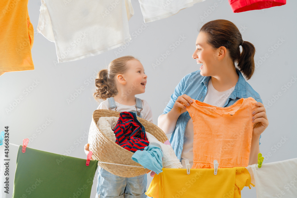 妇女和女孩把衣服挂在绳子上