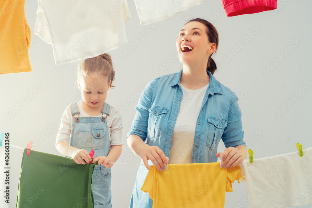 妇女和女孩把衣服挂在绳子上