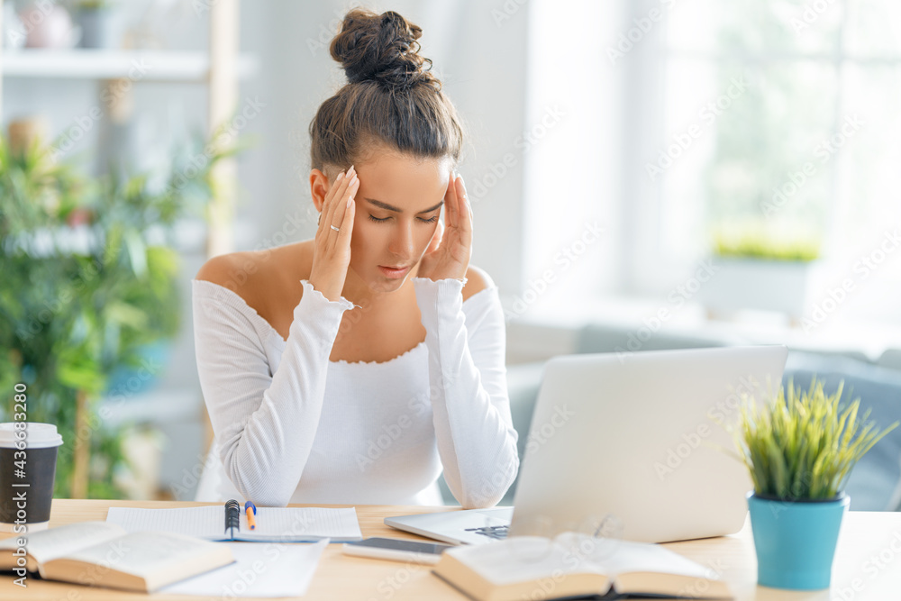 Young woman studying and having a head ache