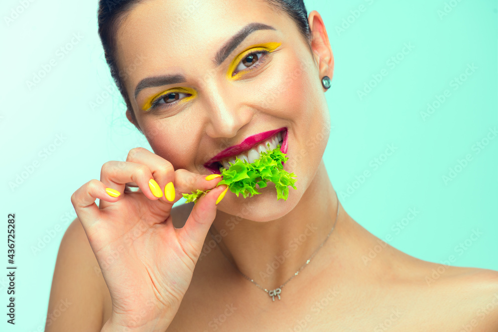 健康饮食。美丽健康的女孩吃生素食，面带微笑。美丽年轻时尚