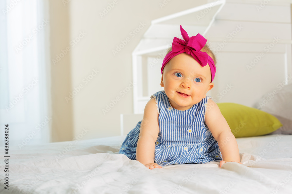 Portrait of a beautiful baby girl in dress and bow