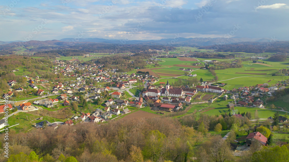 DRONE: Small cloister on outskirts of a village in vibrant green rural Slovenia.