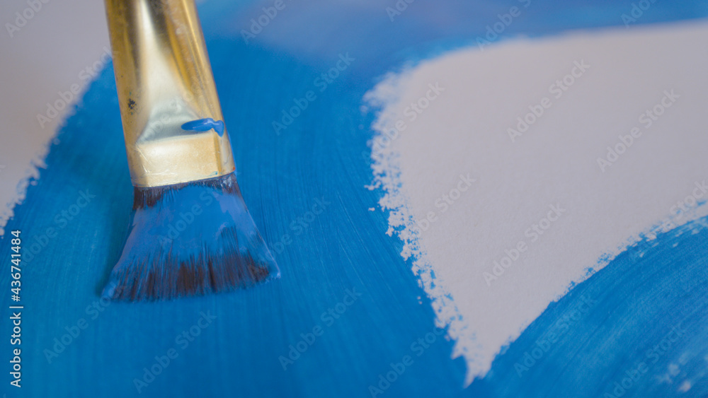 CLOSE UP, DOF: Artist drags their paintbrush across a blank slate of paper.