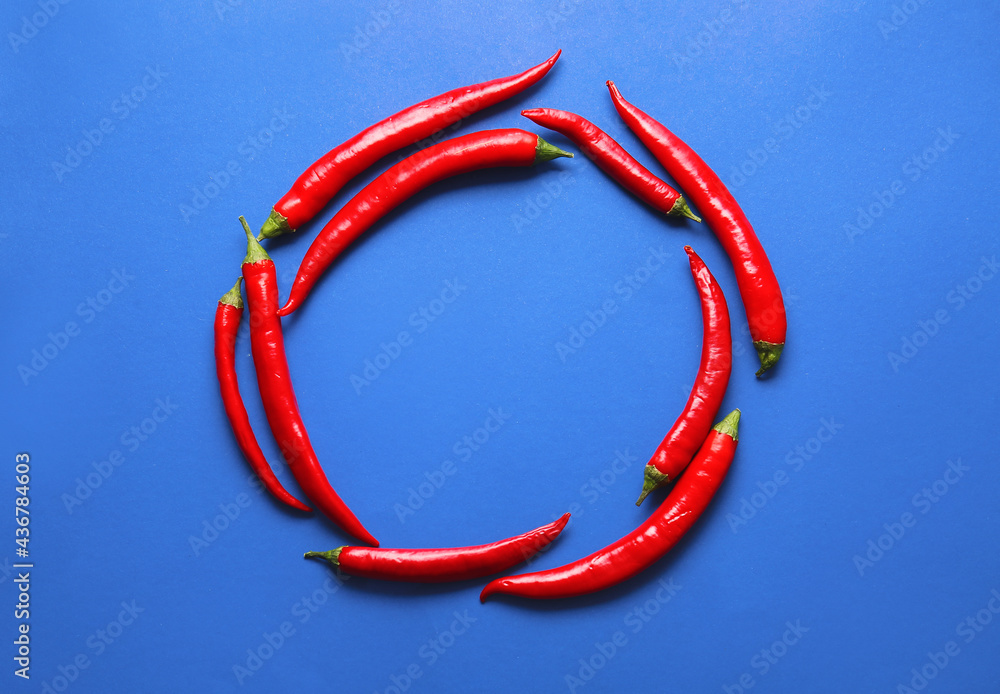 Frame made of hot chili peppers on color background