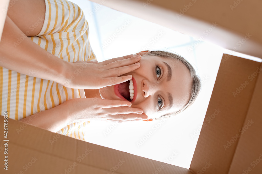 Happy young woman with open box, view from inside