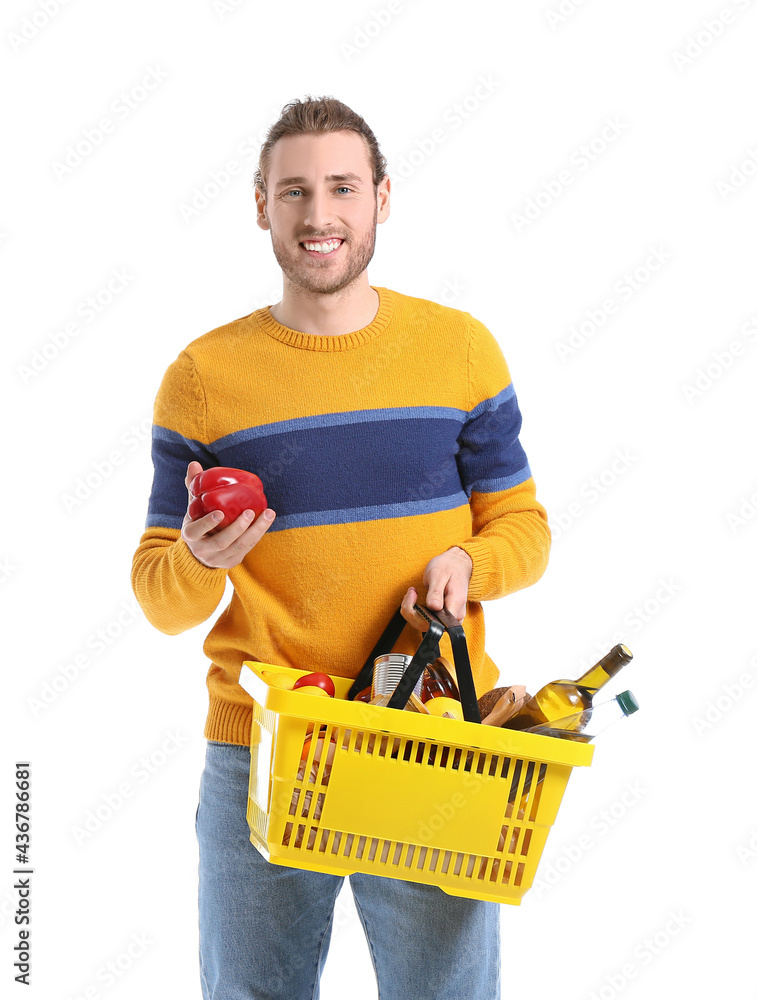 Young man with shopping basket on white background