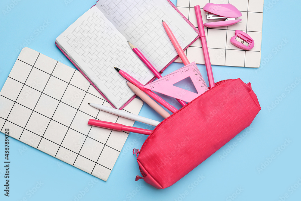 Pencil case and stationery on color background