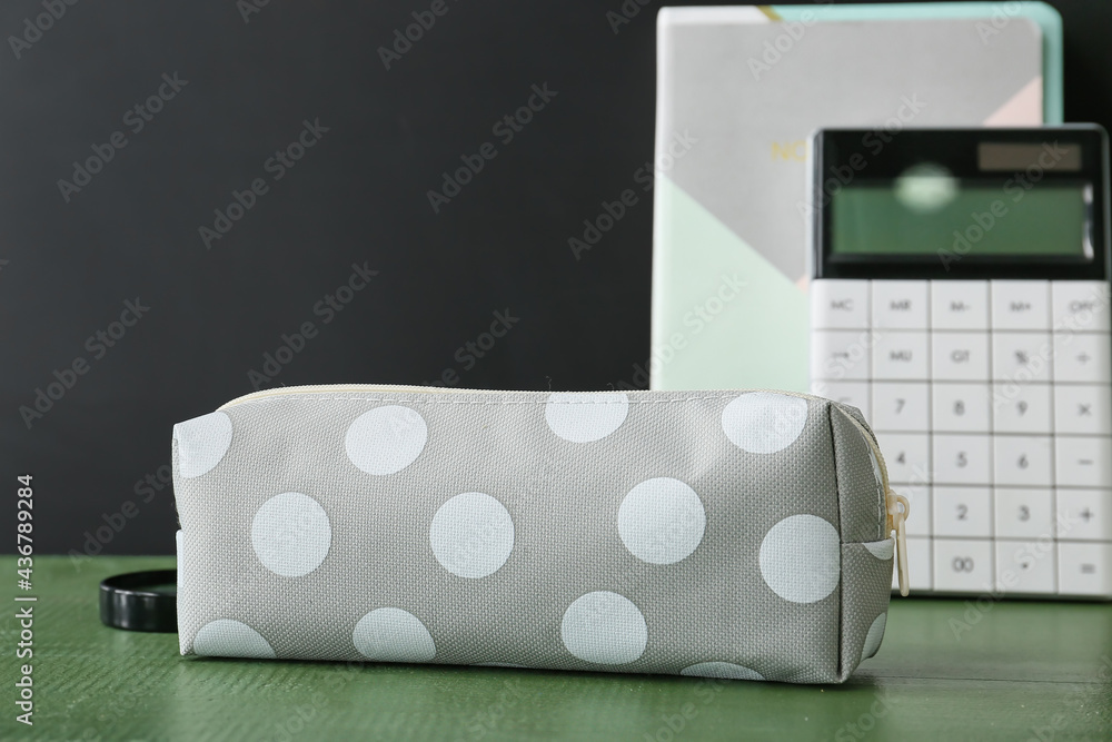 Pencil case and stationery on dark background